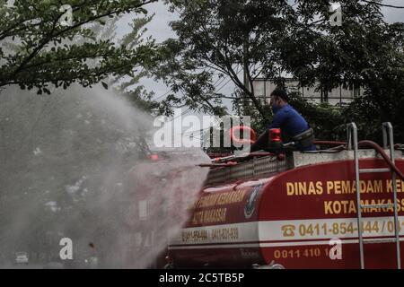 Makassar, Süd-Sulawesi, Indonesien. Juli 2020. Feuerwehrleute sprühten Desinfektionsmittel mit Autos auf den Straßen von Makassar, Indonesien. Das Spritzen wird regelmäßig durchgeführt, um die Ausbreitung des Covid-19-Ausbruchs zu verhindern. Quelle: Herwin Bahar/ZUMA Wire/Alamy Live News Stockfoto