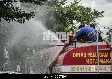 Makassar, Süd-Sulawesi, Indonesien. Juli 2020. Feuerwehrleute sprühten Desinfektionsmittel mit Autos auf den Straßen von Makassar, Indonesien. Das Spritzen wird regelmäßig durchgeführt, um die Ausbreitung des Covid-19-Ausbruchs zu verhindern. Quelle: Herwin Bahar/ZUMA Wire/Alamy Live News Stockfoto