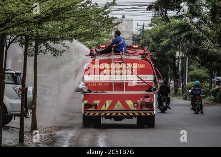 Makassar, Süd-Sulawesi, Indonesien. Juli 2020. Feuerwehrleute sprühten Desinfektionsmittel mit Autos auf den Straßen von Makassar, Indonesien. Das Spritzen wird regelmäßig durchgeführt, um die Ausbreitung des Covid-19-Ausbruchs zu verhindern. Quelle: Herwin Bahar/ZUMA Wire/Alamy Live News Stockfoto