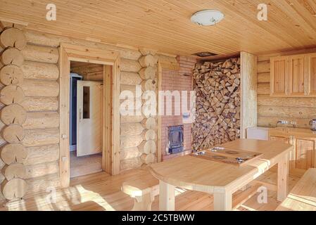 Ein hölzerner Aufenthaltsraum, nach einem Besuch in der Sauna, wo Sie an einem Holztisch in der Nähe des Kamins sitzen können. Stockfoto