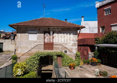 Guimarães, Portugal - schöne erhaltene mittelalterliche bunte traditionelle Steinhäuser mit Holzfenstern und kleinen Balkonen und Blumentopf Stockfoto