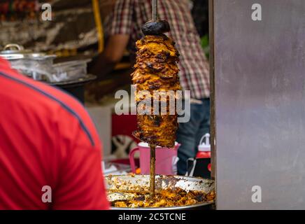 Huhn in einem rotierenden Spieß gegrillt, um ein nahöstliches Essen namens Shawarma zu servieren Stockfoto