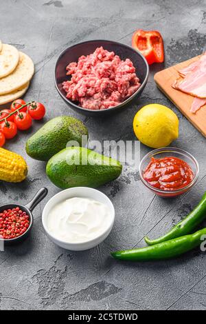 Taco Zutaten hausgemachte Küche mit Gemüse und Huhn Rindfleisch und Schweinefleisch, Mais, Pilze auf grauem Hintergrund Seitenansicht. Stockfoto