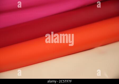 Rollen von farbigem Kunststoffband. Rosa, weinrot, Tomatenbeige. Stockfoto