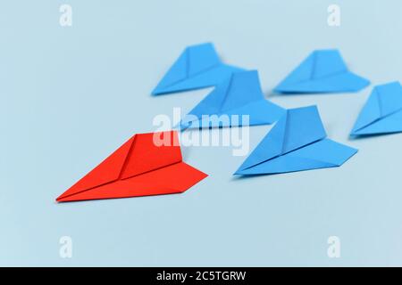 Rotes Papier Flugzeug führenden blauen Flugzeugen. Konzept für Entdeckung und Führung Stockfoto