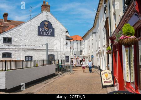 Cromer Norfolk Street, Blick auf ein reifes Paar zu Fuß in der High Street im Zentrum der Nord-Norfolk Küstenstadt Cromer, East Anglia, Großbritannien Stockfoto