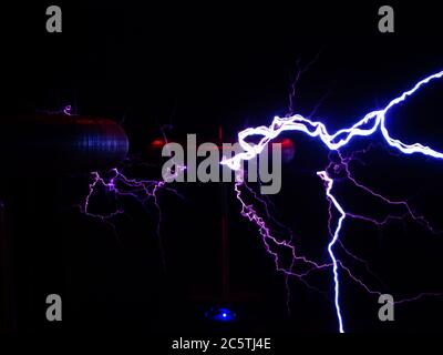 Elektrische Entladung von Blitzen mit den Umrissen der elektrischen Spulen im Dunkeln. Stockfoto