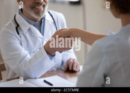 Nahaufnahme eines lächelnden männlichen Arztes und Händeschütteln des Patienten Stockfoto