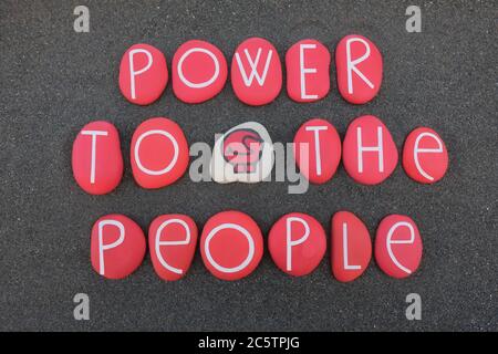 Power to the People, Protest-Slogan mit roten Steinen über schwarzem Vulkansand komponiert Stockfoto