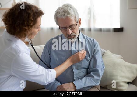 Fürsorgliche Ärztin hören Herz der reifen Patienten Stockfoto