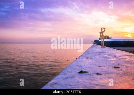 Holzmännchen am Strand mit Blick auf einen wunderschönen, wolkigen Sonnenaufgang vom Pier in Mossel Bay, Mossel Bay, Südafrika Stockfoto