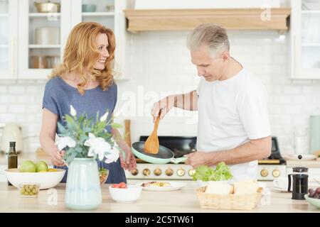 Taille up Porträt von fröhlichen reifen Paar genießen Kochen zusammen zu Hause in der weißen Küche Innenraum, kopieren Raum Stockfoto
