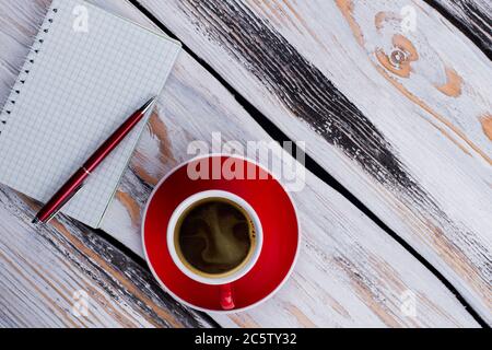 Topview leerer Keramikbecher und Notizblock mit einem Stift. Stockfoto