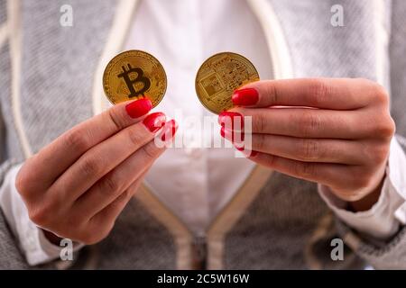 Virtuelle cryptocurrency Geld Bitcoin goldenen Münzen in den Händen einer Frau mit roten Nagellack. Die Zukunft des Geldes. Stockfoto