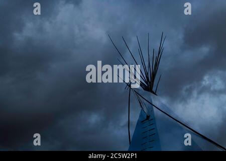 Ein Indianertipi (oder Tipi) der First Nations An einem regnerischen Tag aus einer nebligen Wolke hervortreten Kanada Stockfoto