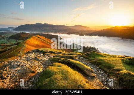 Schöner Sonnenaufgang mit Blick auf Derwentwater von Catbells an EINEM sonnigen ruhigen Morgen mit Cloud Inversion Mist über dem See. Lake District National Park, Großbritannien. Stockfoto