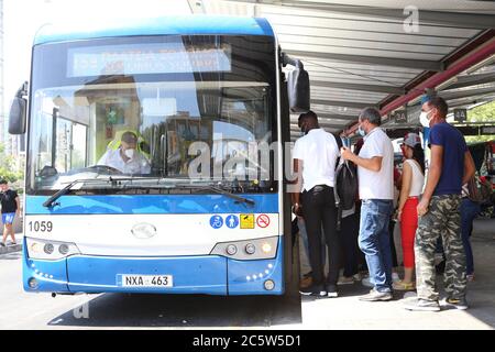 Nikosia, Zypern. Juli 2020. Passagiere warten auf einen Bus, der aus China in Nikosia, Zypern, am 5. Juli 2020 importiert wurde. Viele Pendler in Zypern können jetzt eine grünere Busfahrt bekommen, wie die erste Charge von 155 schlanken blau und weiß emissionsarme Busse nahm zum ersten Mal auf die Straßen am Sonntag. Die Flotte der "King Long" chinesischen Fahrzeuge -- alle umweltfreundlich nach der Euro 6-Norm -- wurde in der Hauptstadt Nikosia und der Küstenstadt Larnaca gestartet. DAZU:Feature: Chinesische emissionsarme Busse in Zypern ausrollen Kredit: Zhang Baoping/Xinhua/Alamy Live News Stockfoto