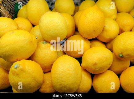 Bunt von gelb Display von Zitronen in einem Korb auf Bio-Markt oder Lebensmittelgeschäft. Bio frische Zitronen Hintergrund Nahaufnahme. Frische Zitronen gesunde Vitami Stockfoto