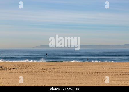 Blick auf das Meer vom Huntington Beach an der kalifornischen Küste, mit Paddelboardern auf dem Wasser Stockfoto