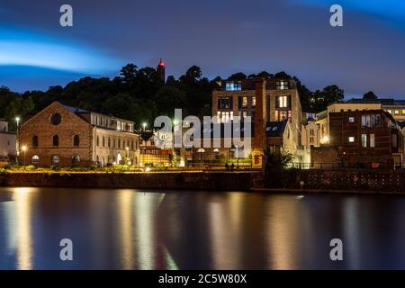 Renovierte und umgebaute ehemalige Industriegebäude und Neubauwohnungen werden nachts an der erneuerten Hafenanlage von Bristol beleuchtet. Stockfoto