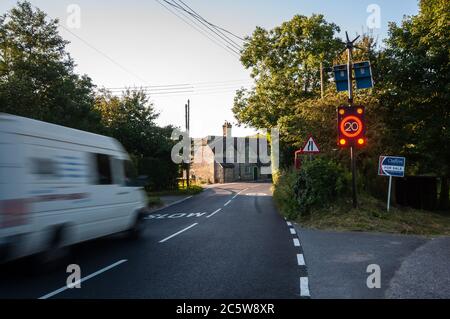 Shaftesbury, England, UK - 28. Juli 2012: Verkehr rauscht durch Melbury Abbas Dorf im ländlichen Norden Dorset, aktivieren eine elektronische Geschwindigkeitsbegrenzung Sig Stockfoto