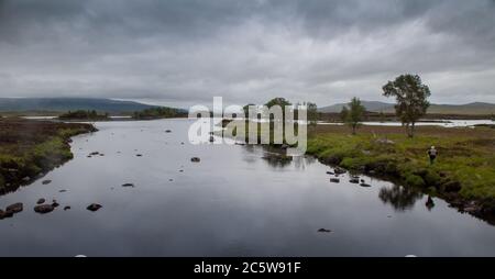 Glencoe, Schottland, UK - 4. Juni 2011: Ein Fischer steht am Ufer des Flusses Ba in der Feuchtgebietslandschaft von Rannoch Moor in den West Highlands o Stockfoto