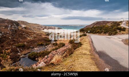 Die A838 Road, Teil der North Coast 500 Touring Route, windet sich an Sandstränden in der Nähe von Durness im hohen Norden der Highlands of Scotland vorbei. Stockfoto