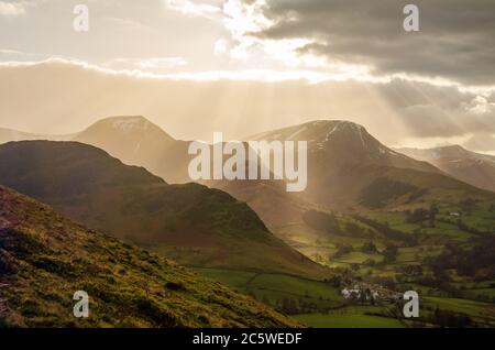Sonnige und dunstig Blick von Catbells in Lake District, zeigt ein Dorf und in der Nähe von Bergen und Hügeln Stockfoto