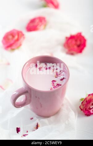 Mondmilch bereitet sich mit rosa Rosenblüte. Trendige entspannende Schlafenszeit Getränk Form ayurvedischen Traditionen Stockfoto