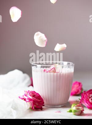 Mondmilch bereitet sich mit rosa Rosenblüte. Trendige Schlafenszeit Getränk Form ayurvedischen Traditionen Stockfoto