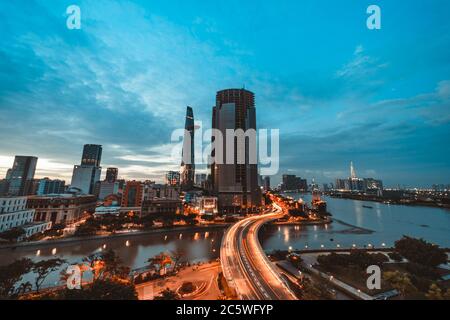 SAIGON, VIETNAM - 04. JULI 2020: Ho Chi Minh Stadt bei Nacht, Khanh Hoi Brücke, gelbe Spur auf der Straße, das Gebäude im Bild ist bitexco Turm, weit entfernt Stockfoto