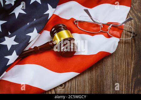 Justizbüro Anwalt am Tisch arbeiten hölzernen Richter Hammer und Gläser auf amerikanische Flagge Holztisch Stockfoto