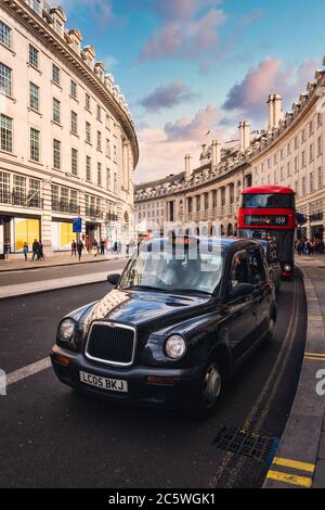 Typisches schwarzes Taxi und roter Doppeldeckerbus in der Regent Street in London Stockfoto