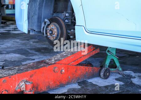 Räder auf ein Auto ersetzen, hält Jack den Körper in angehobener Stellung Stockfoto