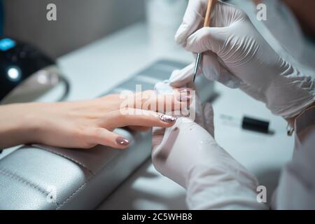 Nahaufnahme und Maniküre Künstler machen Nagel Reinigung und Polieren Stockfoto