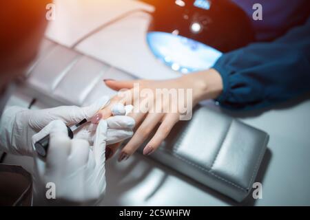 Nahaufnahme und Maniküre Künstler machen Nagel Reinigung und Polieren Stockfoto