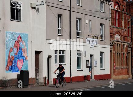 Loughborough, Leicestershire, Großbritannien. Juli 2020. Ein Mann radelt an einem Wandgemälde vorbei, das dem National Health Service anlässlich seines 72. Jahrestages während der Coronavirus-Pandemie Tribut zollt. Credit Darren Staples/Alamy Live News. Stockfoto