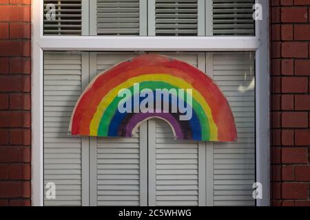 Ein gemalter Regenbogen im Fenster eines Hauses in Cardiff, Großbritannien während der Coronavirus-Sperrzeit. Stockfoto