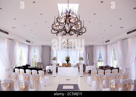 Leerer geschlossener Hochzeitsraum oder Standesamt mit auffälligen modernen Kronleuchtern. Stockfoto