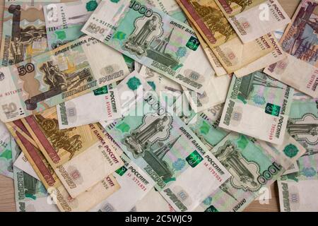 Geld, russische Banknoten verschiedener Konfessionen sind auf dem Tisch verstreut. Stockfoto