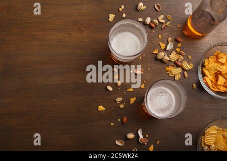 Bier und Entspannung. ALE in Flaschen und Gläsern, Chips, Nüssen und Pistazien Stockfoto
