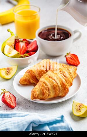 Frühstück Croissants mit Kaffee, Saft und Obst, weißer Hintergrund. Stockfoto