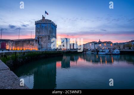 Der alte Hafen von La Rochelle bei Sonnenuntergang mit seinen berühmten alten Türmen. Schöner oranger Himmel Stockfoto