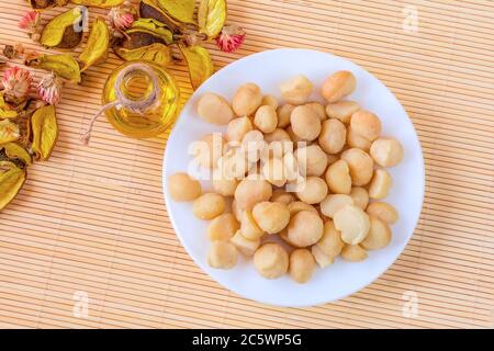 Schale mit Macadamia-Nussöl und Nüssen, gesundes Lebensmittelkonzept, Draufsicht Stockfoto