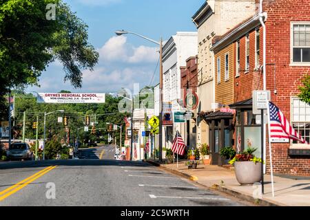 Orange, USA - 9. Juni 2020: Historische Innenstadt Stadt in Virginia Landschaft mit Backsteinbauten amerikanische Flagge auf der Straße und Zeichen für die Schule, sto Stockfoto