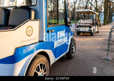 Warschau, Polen - 20. Dezember 2019: Warszawa Lazienki oder Royal Baths Park mit Museum Wachen Sicherheit Golfwagen Autos Zeichen blaue Farbe und niemand Stockfoto