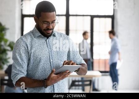 Konzentrierter afrikanischer Geschäftsmann Vorbereitung Präsentation auf elektronische Tablette Stockfoto