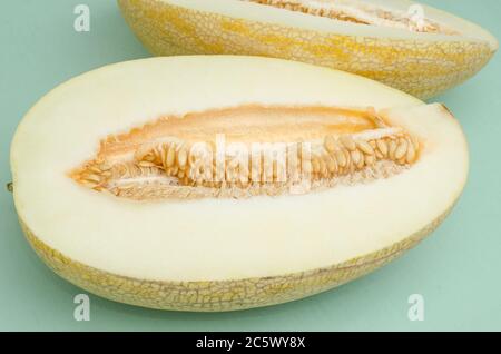 Schneiden Sie halbe Melone auf einem grünen Hintergrund. Sommerdesserts Stockfoto