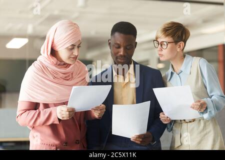 Taille up Porträt von jungen multi-ethnischen Business-Team hält Dokumente während der Diskussion Arbeit Projekt im Büro Stockfoto