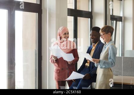 Taille up Porträt von jungen Multi-ethnischen Business-Team lächelnd und halten Dokumente, während die Arbeit im Büro genießen, Kopierer Platz Stockfoto